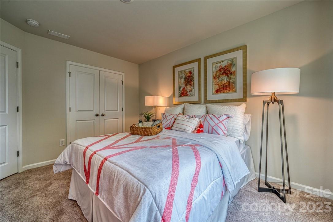 6037 Chelsea Oaks Ridge, Unit 2077 Tega Cay, SC 29708 - Photo 8 of 12 a bedroom with a bed and a night stand