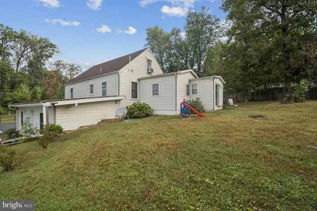 a front view of house with yard and trees in the background