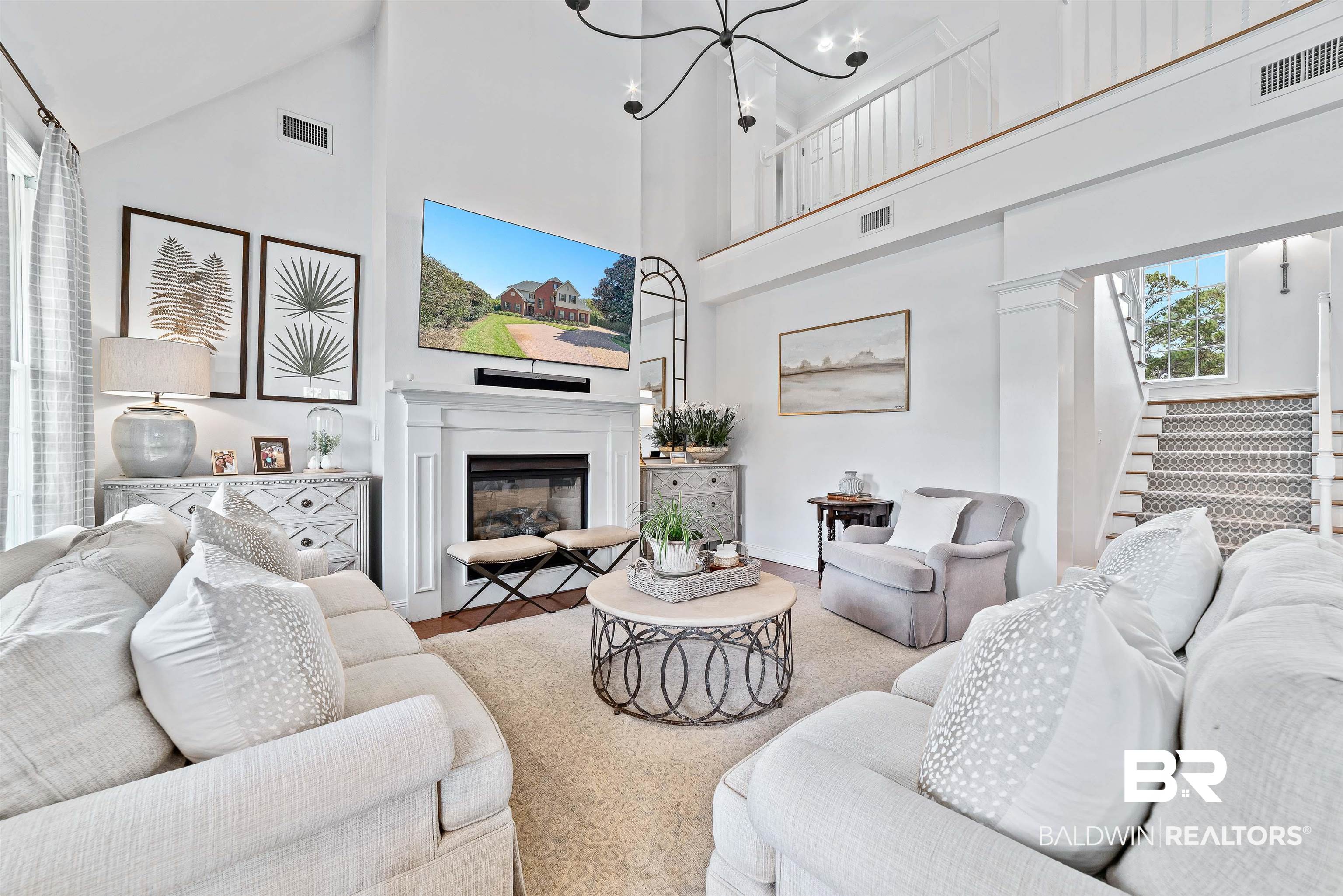 6630 East Quarry Drive Elberta, AL 36530 - Photo 4 of 63 Living area featuring high vaulted ceiling, a glass covered fireplace, stairway, and a chandelier