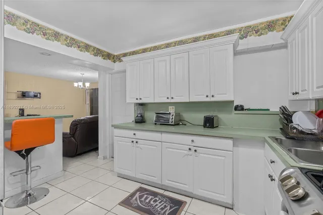a kitchen with stainless steel appliances granite countertop a sink and a white cabinets