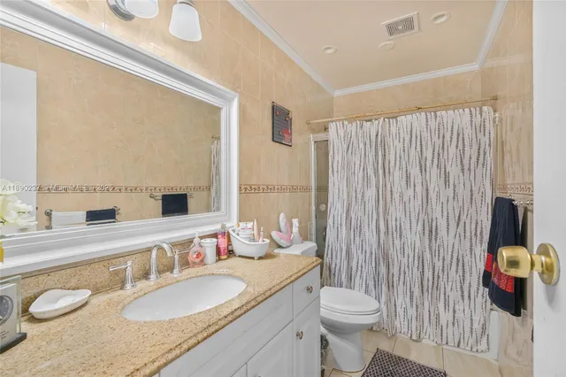 a bathroom with a granite countertop sink and a mirror with toilet