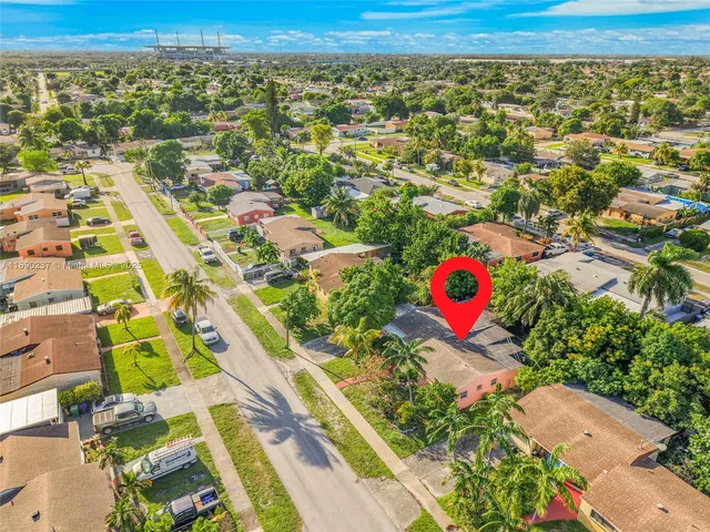 an aerial view of a house with a yard and large trees