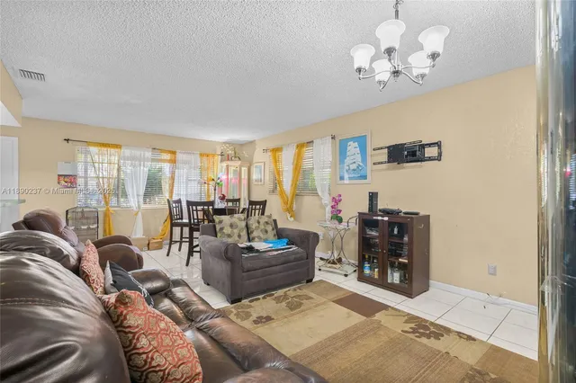a living room with furniture chandelier and a large window