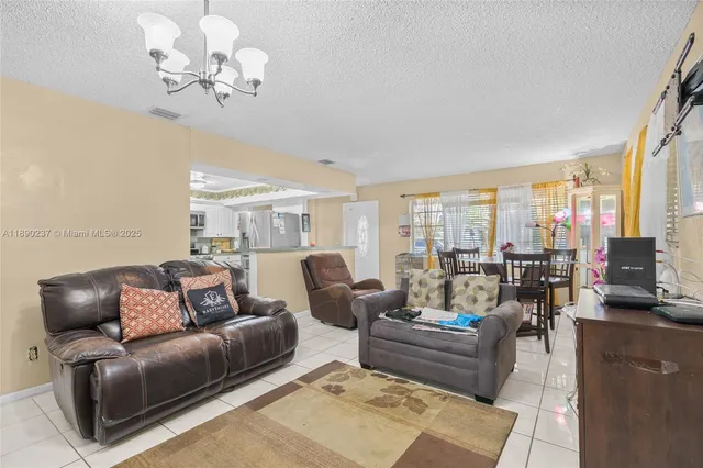 a living room with furniture chandelier and a large window