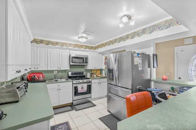 a kitchen with stainless steel appliances granite countertop a refrigerator stove and sink