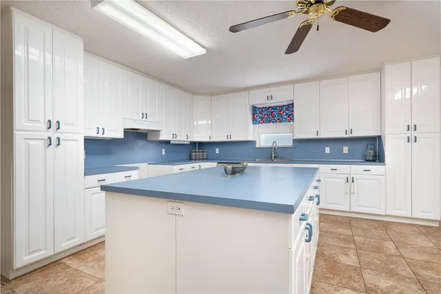 a kitchen with stainless steel appliances granite countertop a sink a stove and white cabinets
