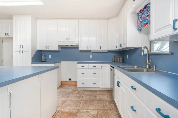 a kitchen with cabinets appliances a sink and a counter top