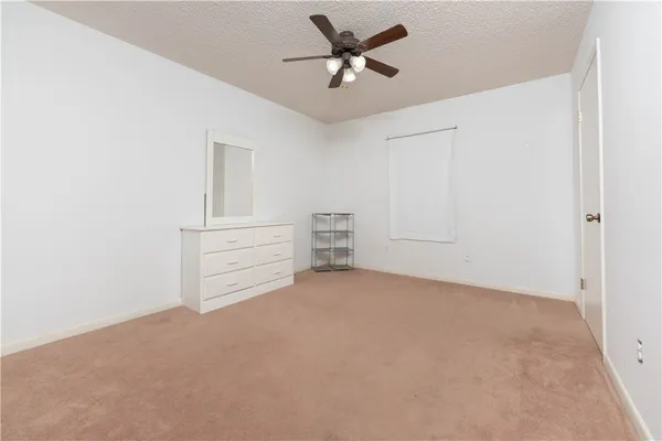 an empty room with closet and ceiling fan