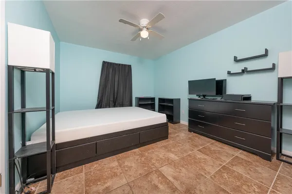 a bedroom with a bed and a ceiling fan