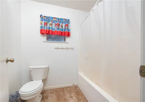 a white toilet sitting next to a white wall