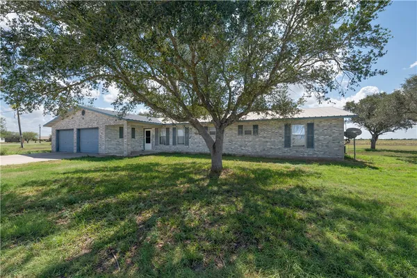 a view of a house with backyard and a tree