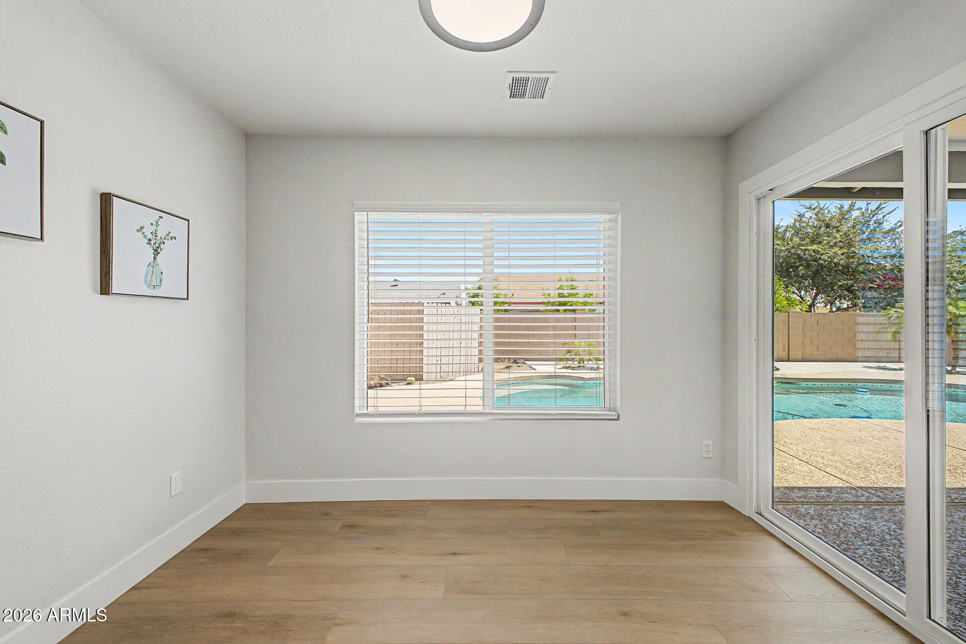 1009 West Pampa Avenue Mesa, AZ 85210 - Photo 9 of 31 an empty room with wooden floor and windows