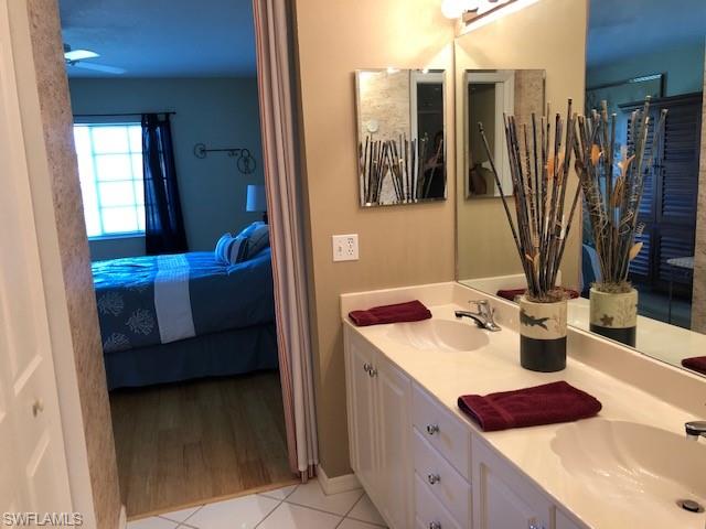 9009 Michael Circle, Unit 1110 Naples, FL 34113 - Photo 18 of 27 a bathroom with a sink a mirror and a shower