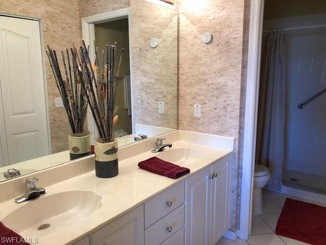 9009 Michael Circle, Unit 1110 Naples, FL 34113 - Photo 19 of 27 a bathroom with a sink and a mirror