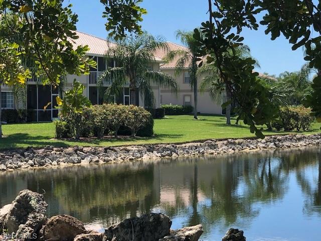 9009 Michael Circle, Unit 1110 Naples, FL 34113 - Photo 27 of 27 a view of a lake with a building in the background