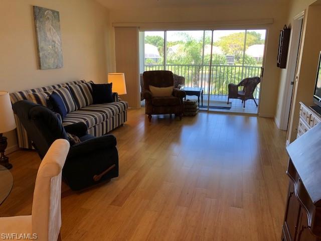 9009 Michael Circle, Unit 1110 Naples, FL 34113 - Photo 3 of 27 a living room with furniture and a large window