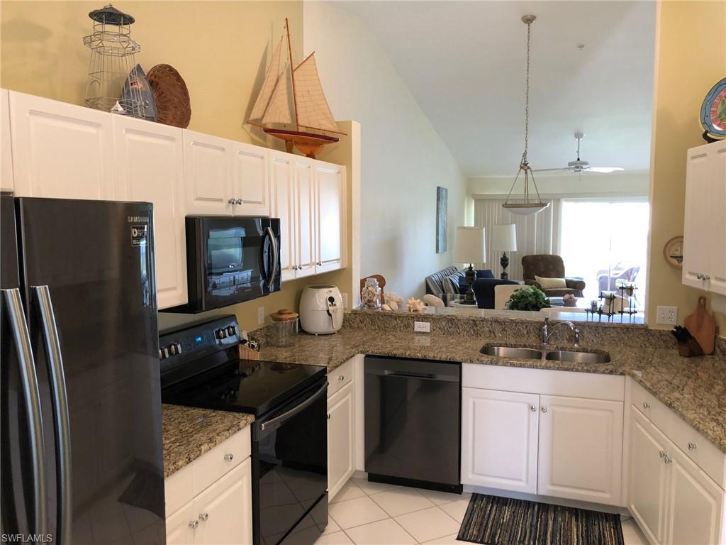 9009 Michael Circle, Unit 1110 Naples, FL 34113 - Photo 7 of 27 a kitchen with stainless steel appliances granite countertop a sink a stove and a refrigerator