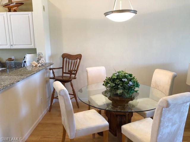 9009 Michael Circle, Unit 1110 Naples, FL 34113 - Photo 9 of 27 a view of a dining room with furniture and wooden floor