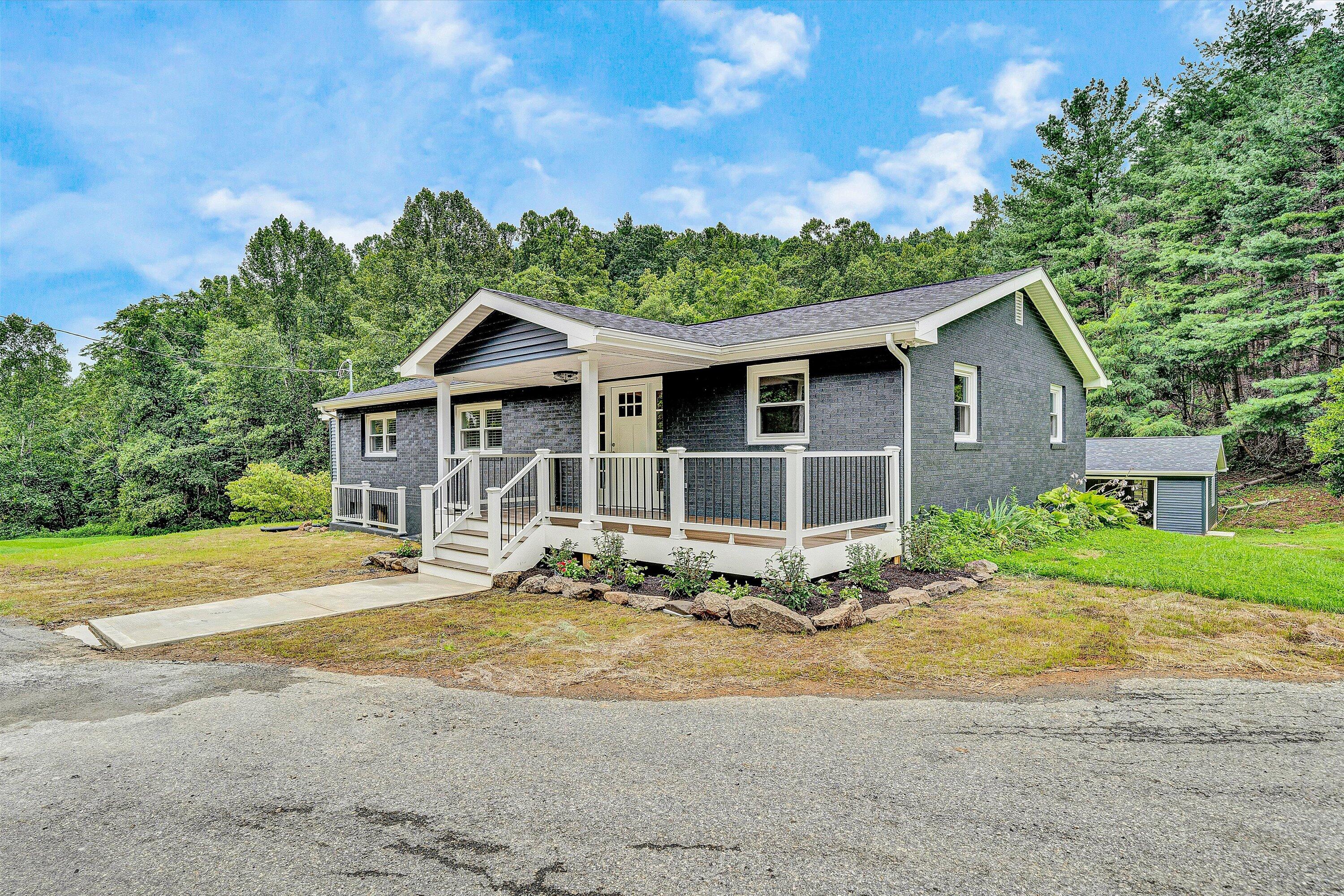 a front view of a house with a garden and yard