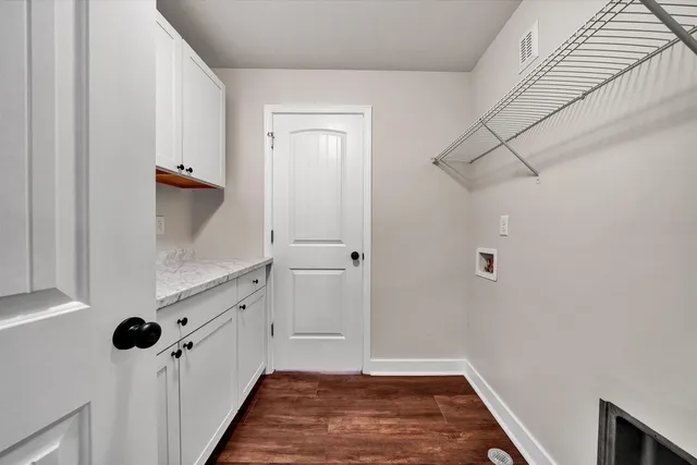 a view of a room with wooden floor and white walls