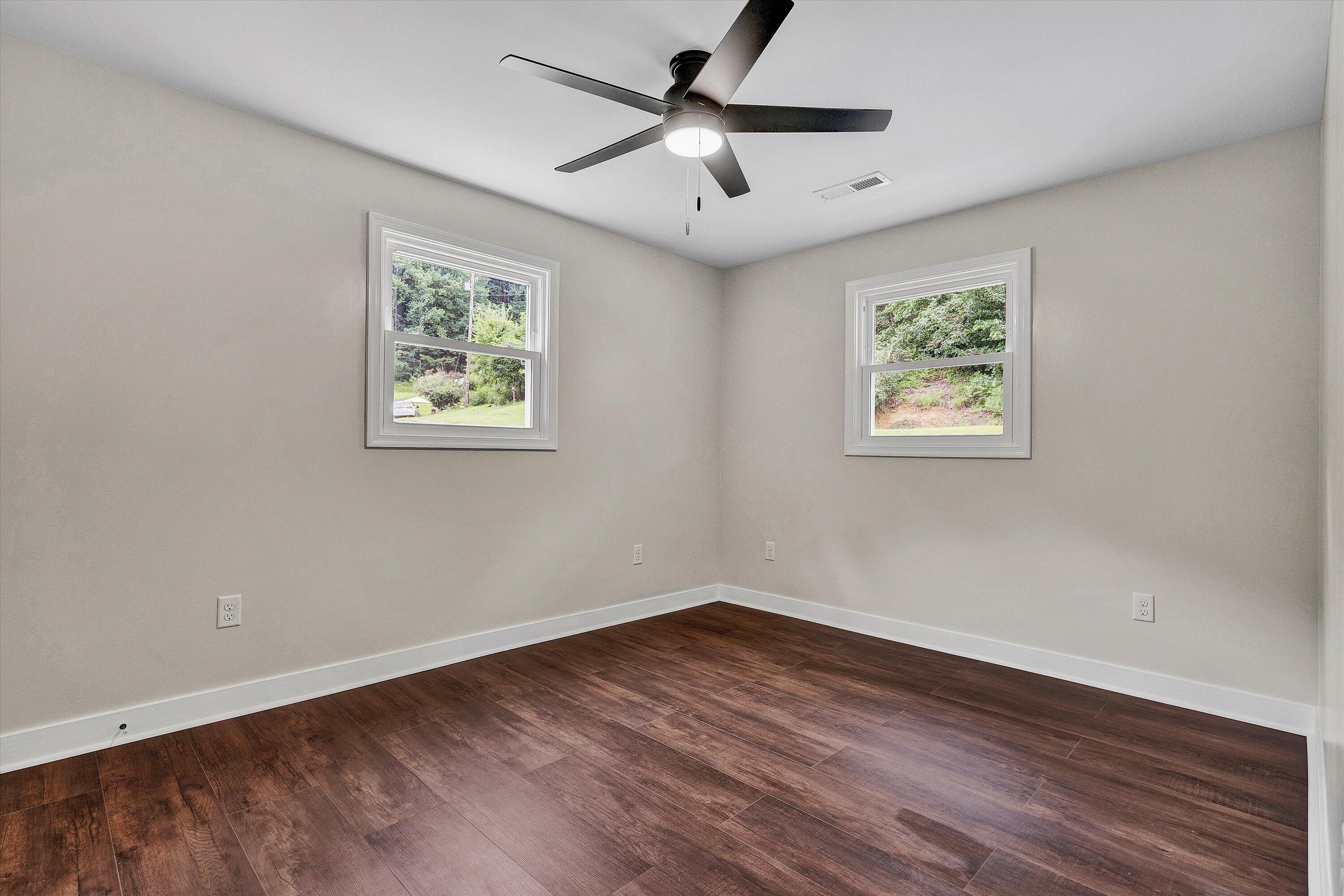 251 Meadow Branch Road Boones Mill, VA 24065 - Photo 18 of 34 a view of an empty room with wooden floor and a ceiling fan