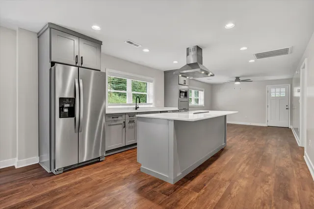 a large kitchen with stainless steel appliances a refrigerator and a sink