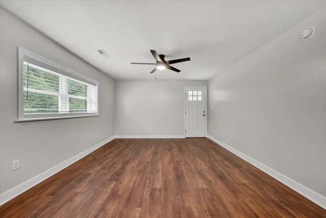 wooden floor in an empty room with a window