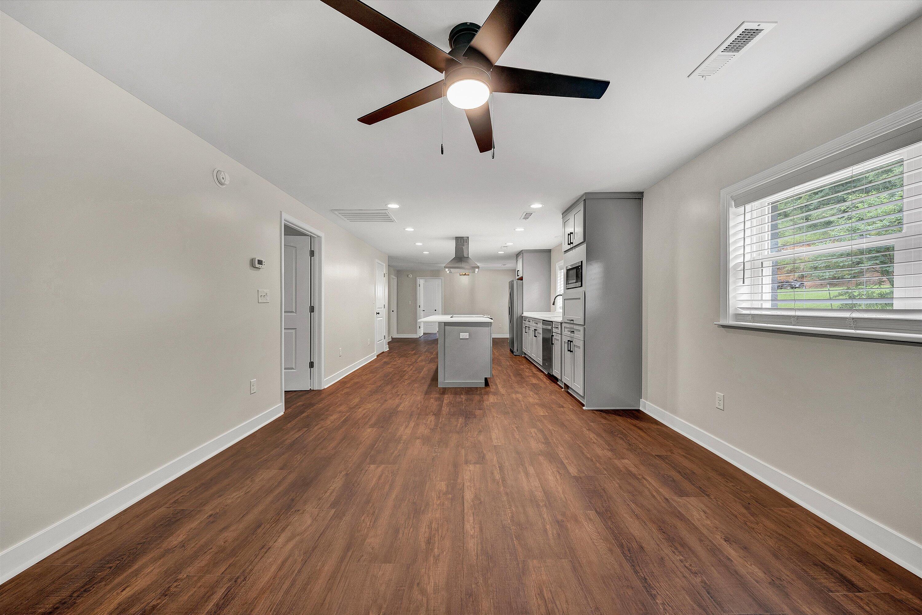 251 Meadow Branch Road Boones Mill, VA 24065 - Photo 10 of 34 a big room with wooden floor a chandelier fan and windows