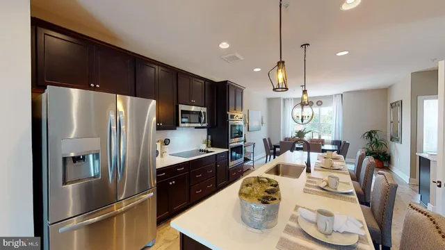 a large kitchen with a table chairs refrigerator and microwave