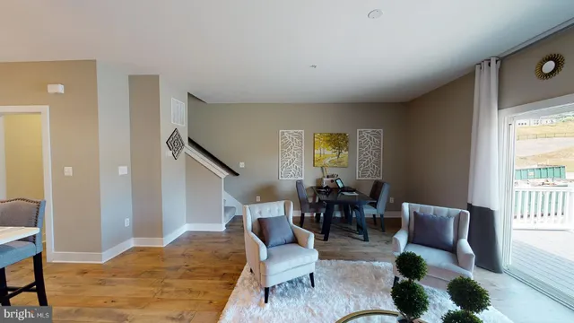 a living room with furniture kitchen view and a potted plant