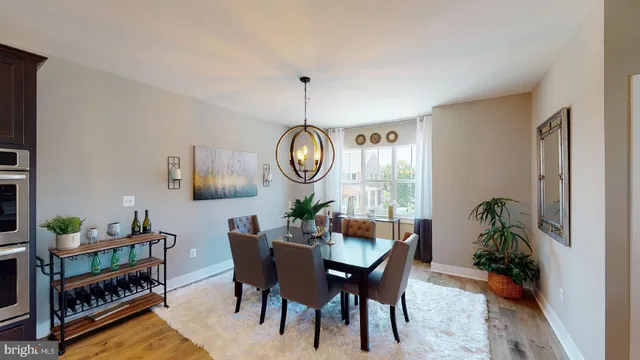 a dining room with furniture a potted plant and wooden floor