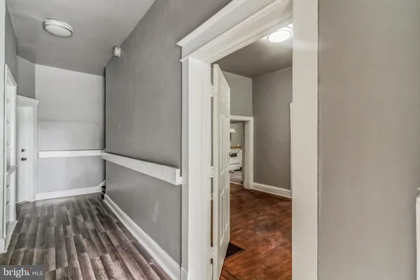 a view of a hallway with wooden floor and staircase