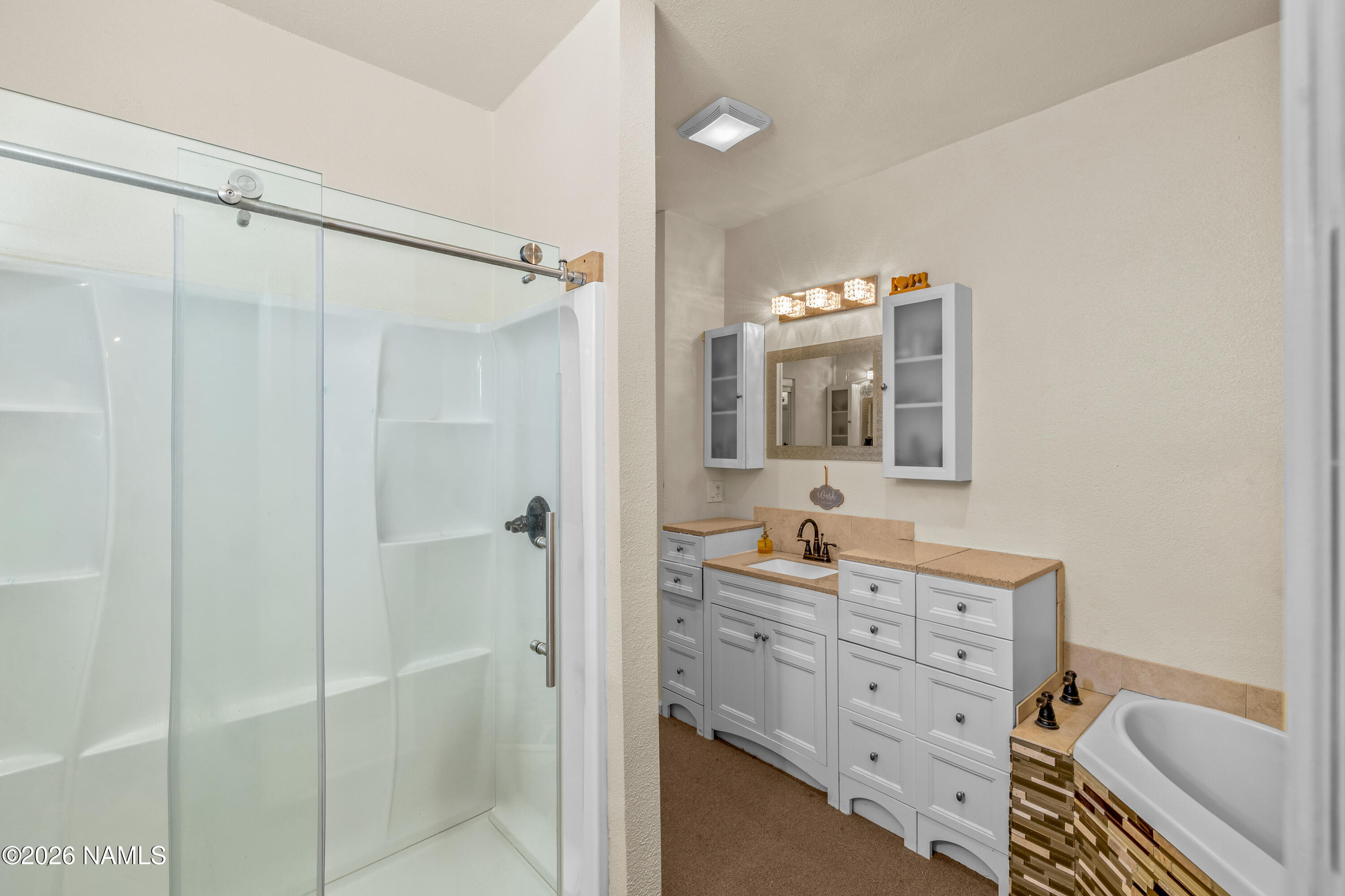 8187 Cassity Trail Williams, AZ 86046 - Photo 21 of 50 a bathroom with a bathtub a sink and a mirror