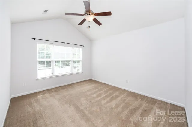 an empty room with a ceiling fan and a window