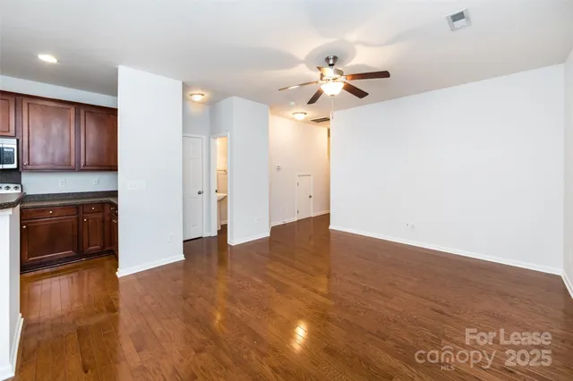 a kitchen with kitchen island granite countertop wooden floors and white stainless steel appliances