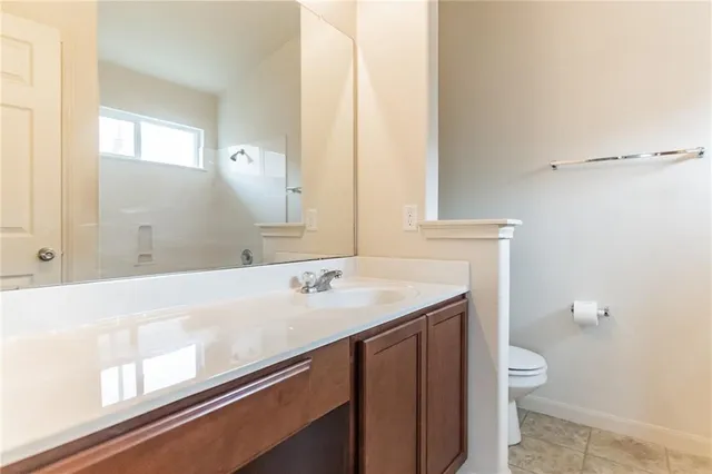 a bathroom with a granite countertop sink a toilet and a mirror