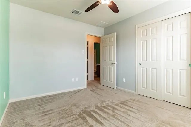 an empty room with closet and windows