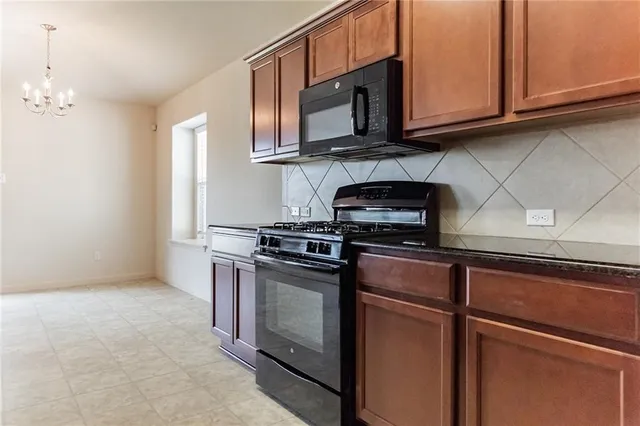 a kitchen with stainless steel appliances granite countertop a stove and a microwave