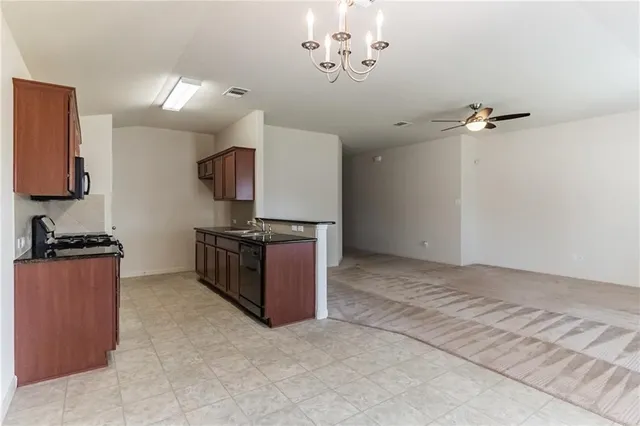 a view of kitchen with a sink a refrigerator and a stove top oven