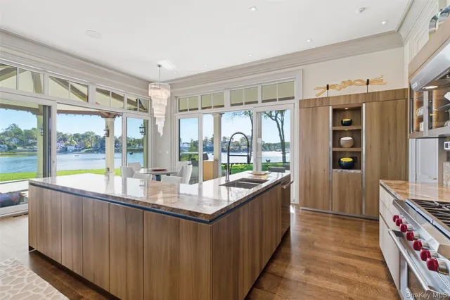 a room with stainless steel appliances granite countertop a sink and a large window