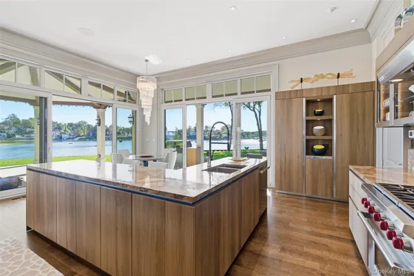 a room with stainless steel appliances granite countertop a sink and a large window