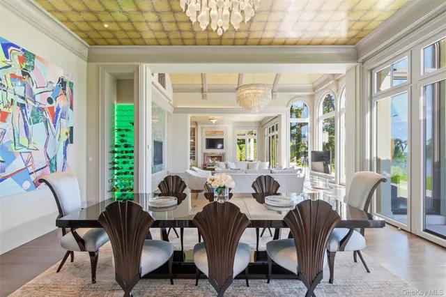 a view of a dining room with furniture a chandelier and wooden floor