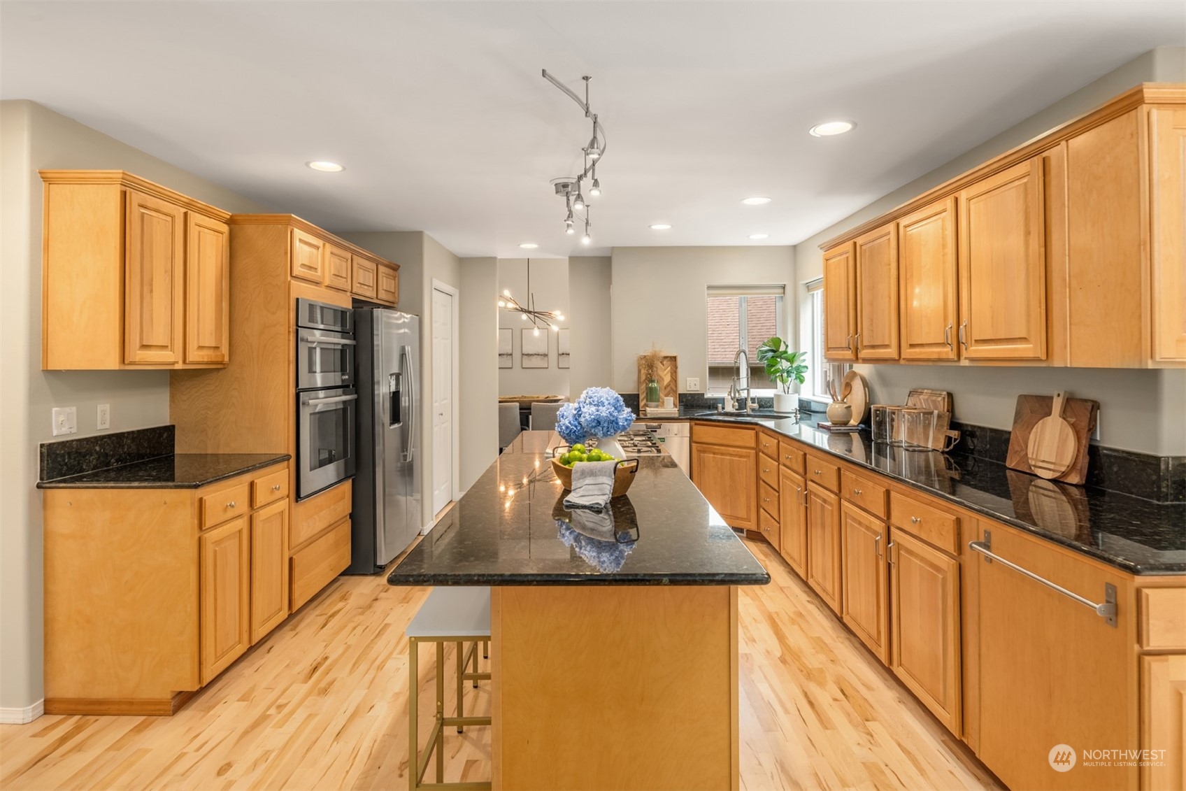 23021 21st Avenue Southeast Bothell, WA 98021 - Photo 8 of 29 a large kitchen with stainless steel appliances granite countertop a refrigerator a sink dishwasher a stove and white countertops with wooden floor