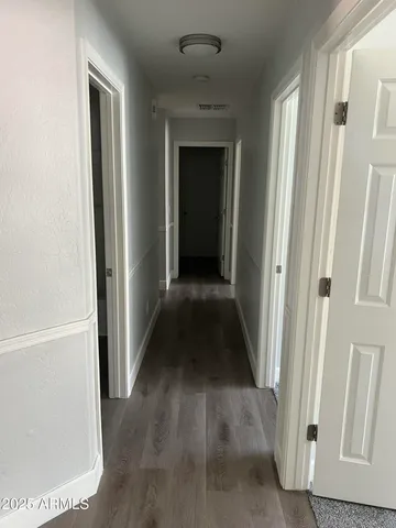 a view of a hallway with wooden floor and staircase
