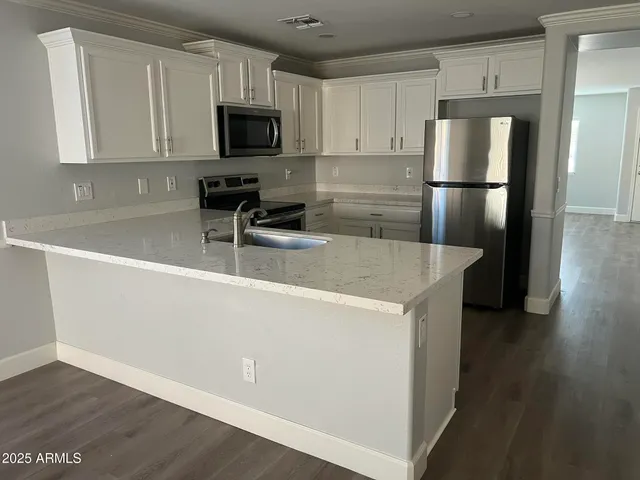 a kitchen with a refrigerator a microwave a sink and cabinets