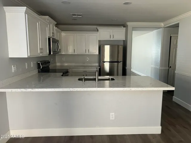a kitchen with a sink a refrigerator and cabinets