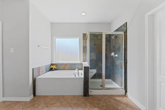 a bathroom with a tub a sink and mirror
