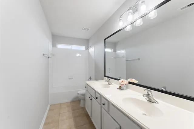 a bathroom with a double vanity sink and a mirror