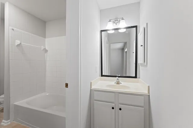a bathroom with a shower a sink and mirror