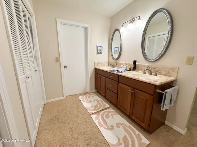 a en suite bathroom with a double vanity sink and a mirror